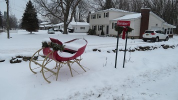 A sleigh and a signpost in the snow.