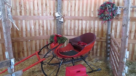 A decorated sleigh in the barn.